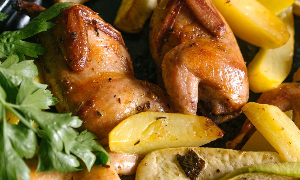 Muslos de pollo asados con papas en bandeja