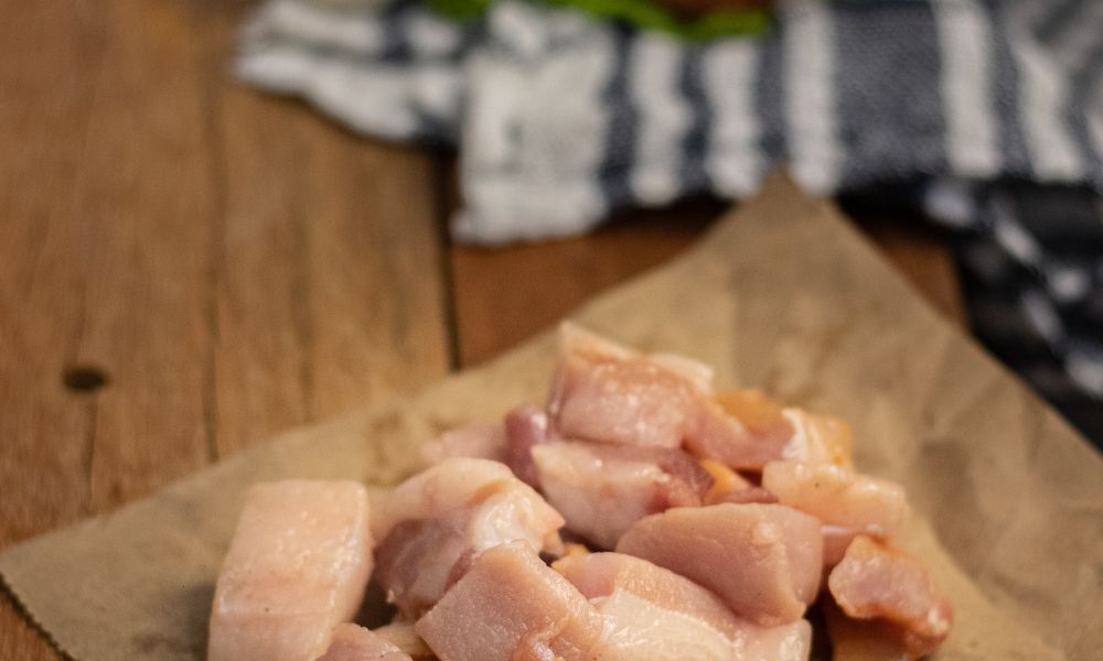 Tocino de cerdo cortado en porciones sobre papel de carnicería