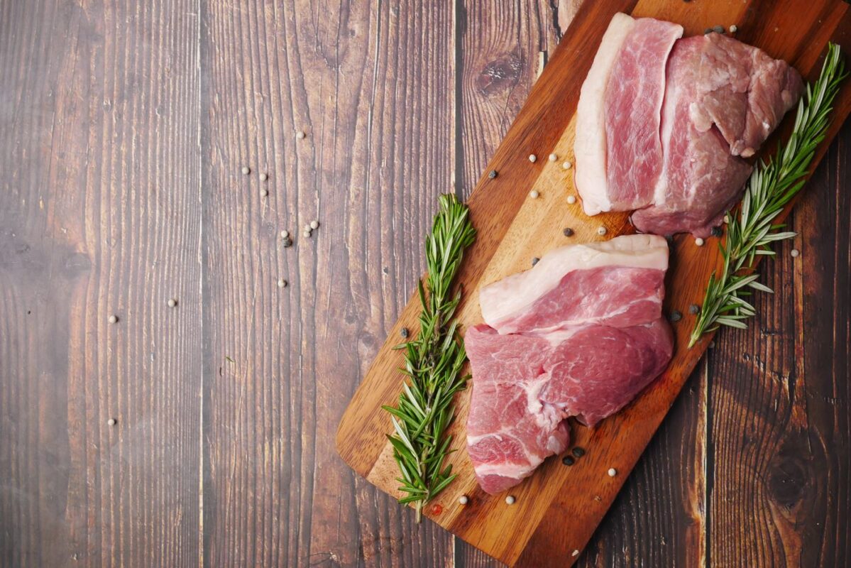 Cortes de cerdo crudos sobre una tabla de cocina