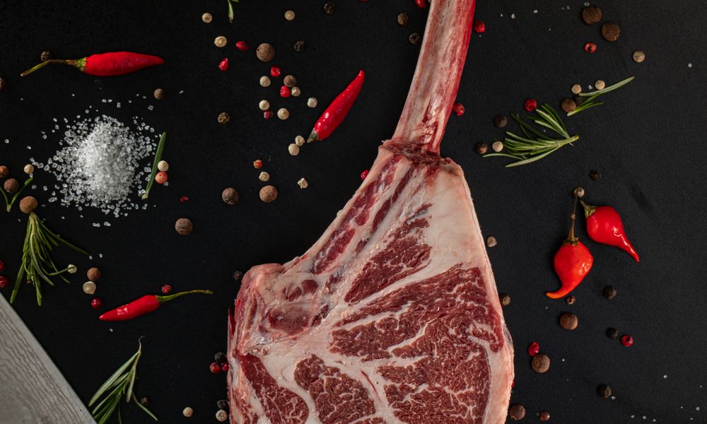 Tomahawk de res crudo con especias y hierbas